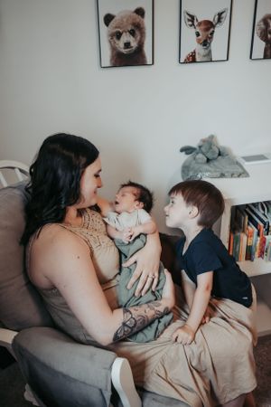 A sweet family moment with children under wall art featuring woodland animals.