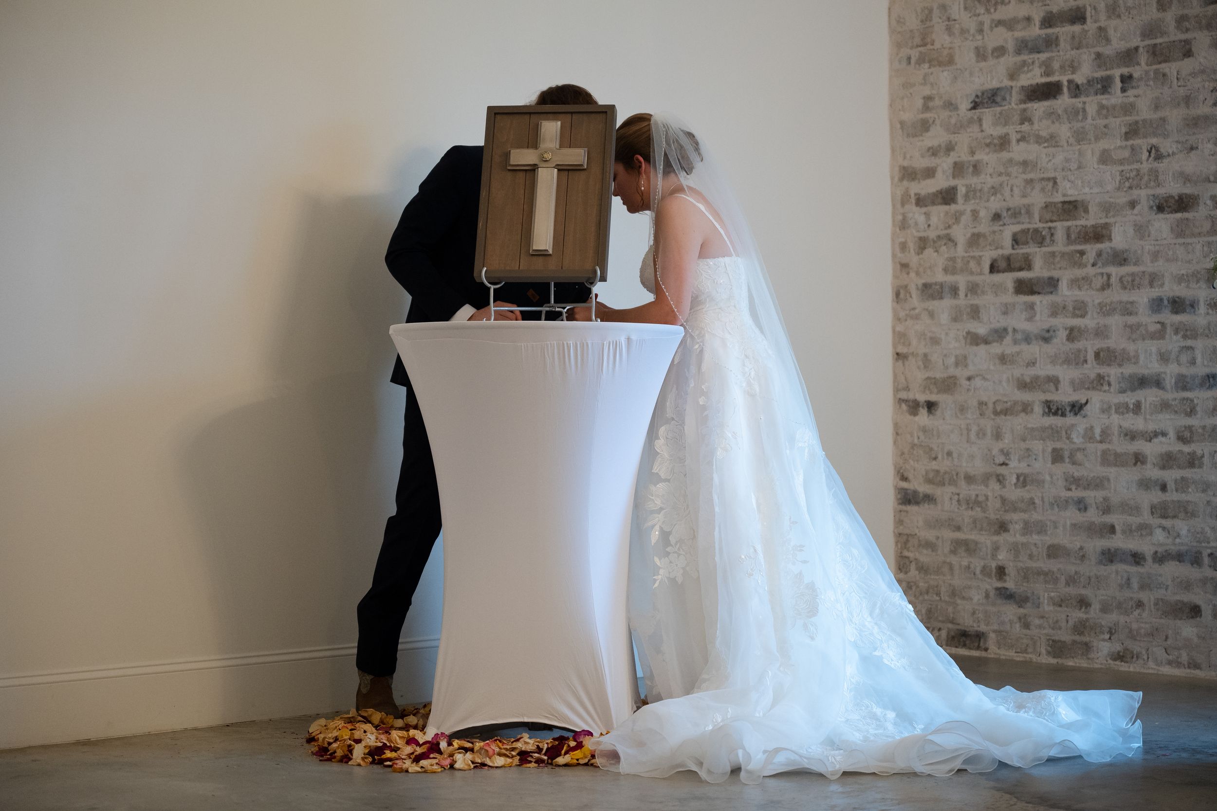 Wedding dress fittings and alterations shown in sequence against a rustic brick wall backdrop.