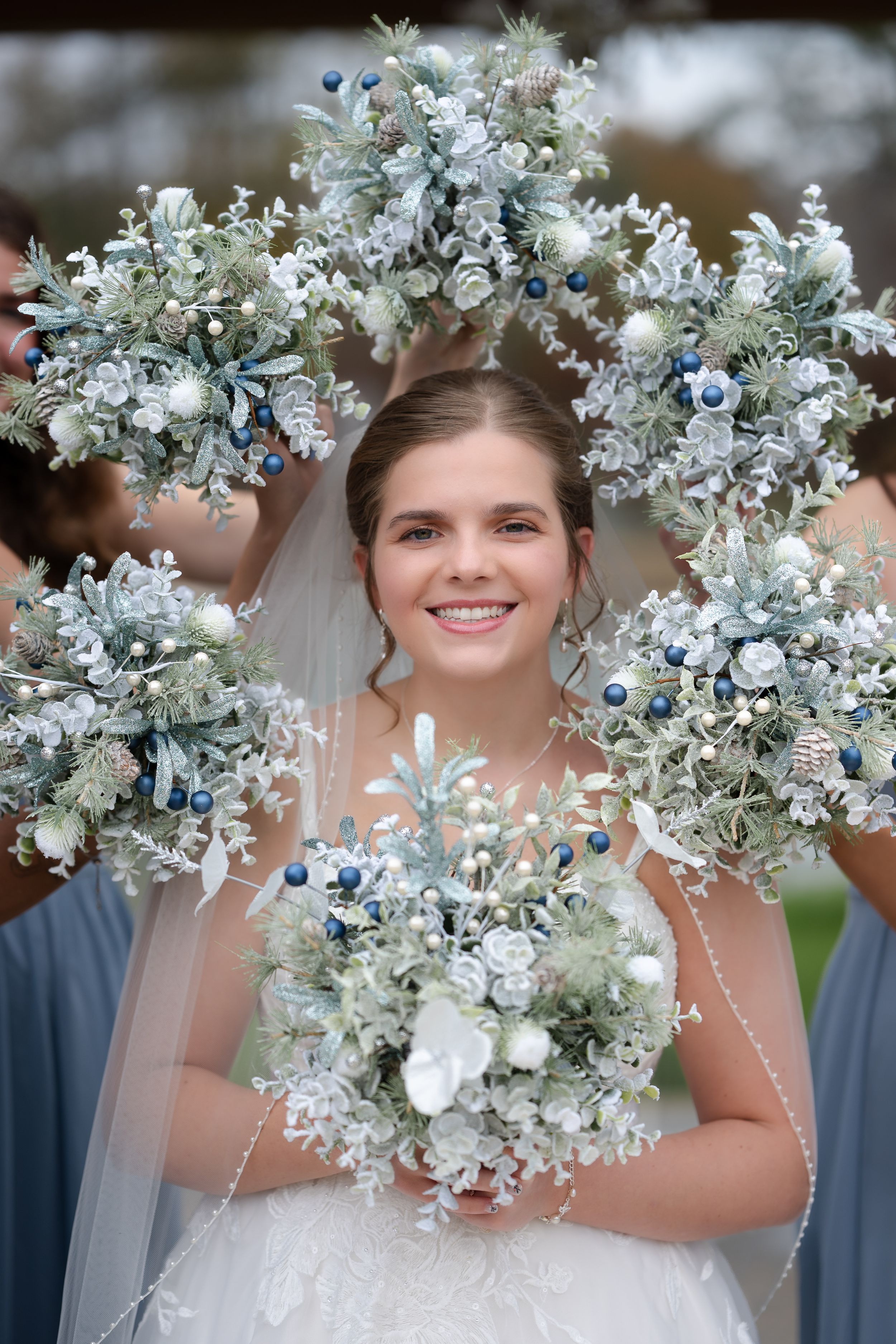 Beautiful winter wedding bouquet and floral crown in shades of white, blue and silver with frosty accents.