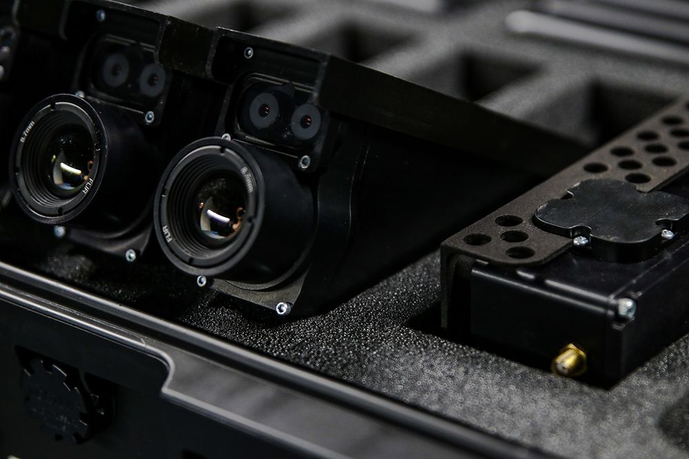 Close-up view of a black audio mixing board with various knobs, faders and control buttons.