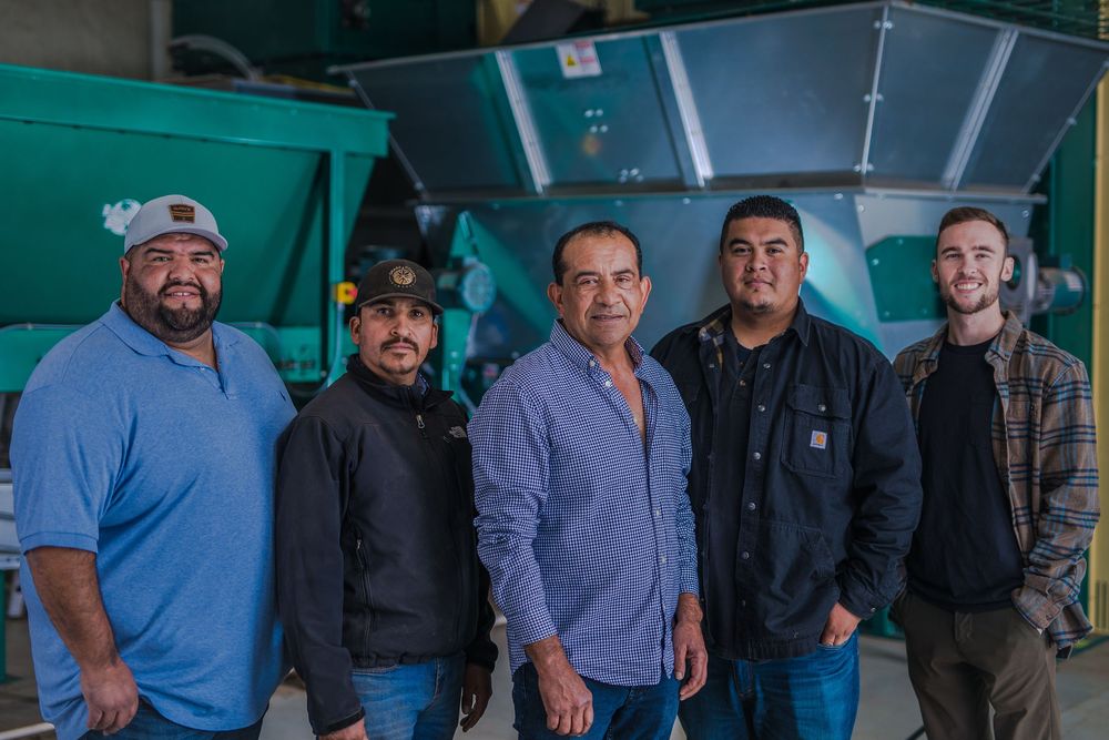 Group of agricultural workers standing together at a saffron farm facility.