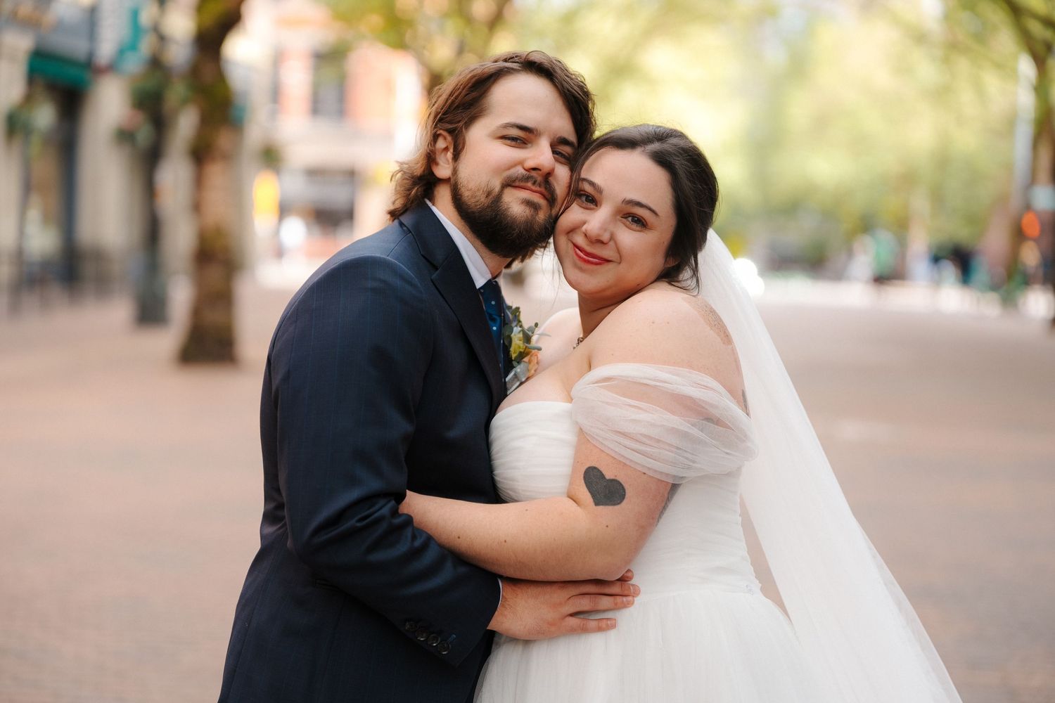 Meghan and Ryker embrace outdoors, sharing a joyful wedding moment in Pioneer Square during their wedding at the 201 venue.
