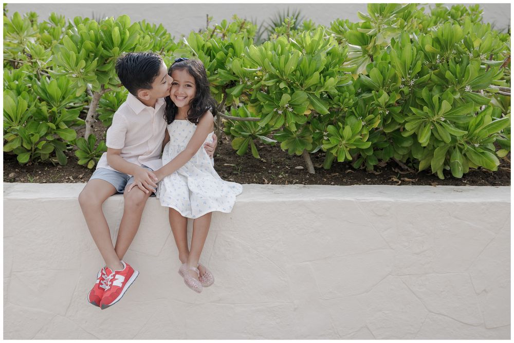 St Regis Punta Mita Family Photographer capturing siblings sharing a kiss outdoors during a Beach Family Photo Session.