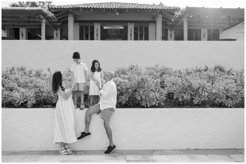 St Regis Punta Mita Family Photographer capturing a family portrait near a green hedge during Punta Mita Family Photos.