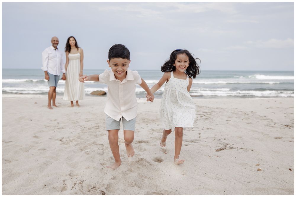 St Regis Punta Mita Family Photographer capturing children running hand in hand on the beach during Beach Family Photo Session.