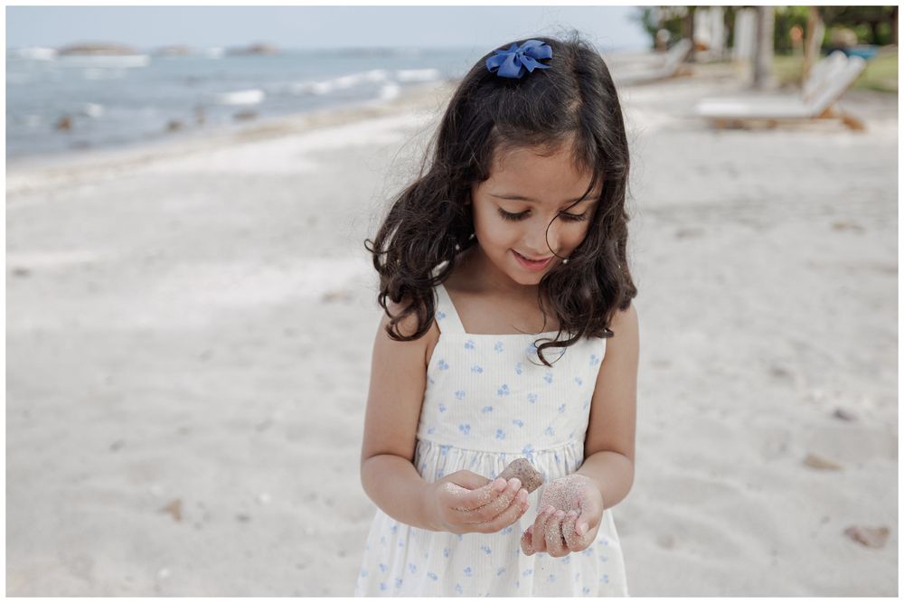 St Regis Punta Mita Family Photographer capturing a young girl exploring a seashell on the beach during Punta Mita Family Photos.