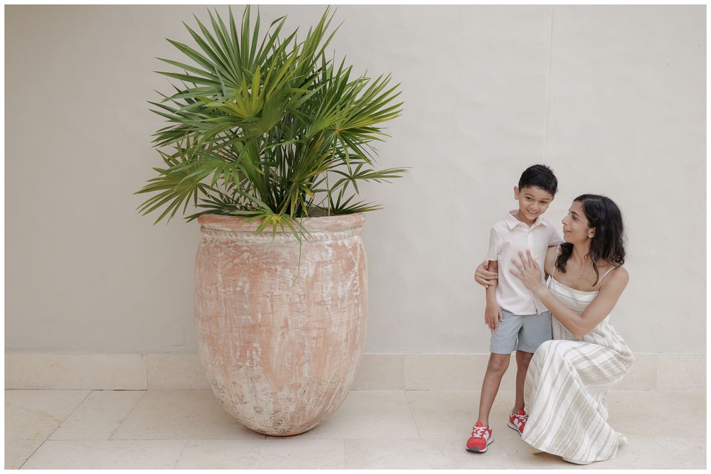 St Regis Punta Mita Family Photographer capturing a family portrait near a terracotta planter and palm during Punta Mita Family Photos