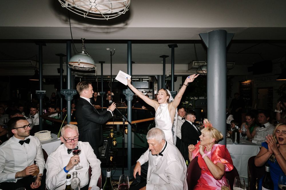Bride and groom celebrate joyfully at elegant wedding reception with guests seated at tables in stylish Pasture Bristol Resturant
