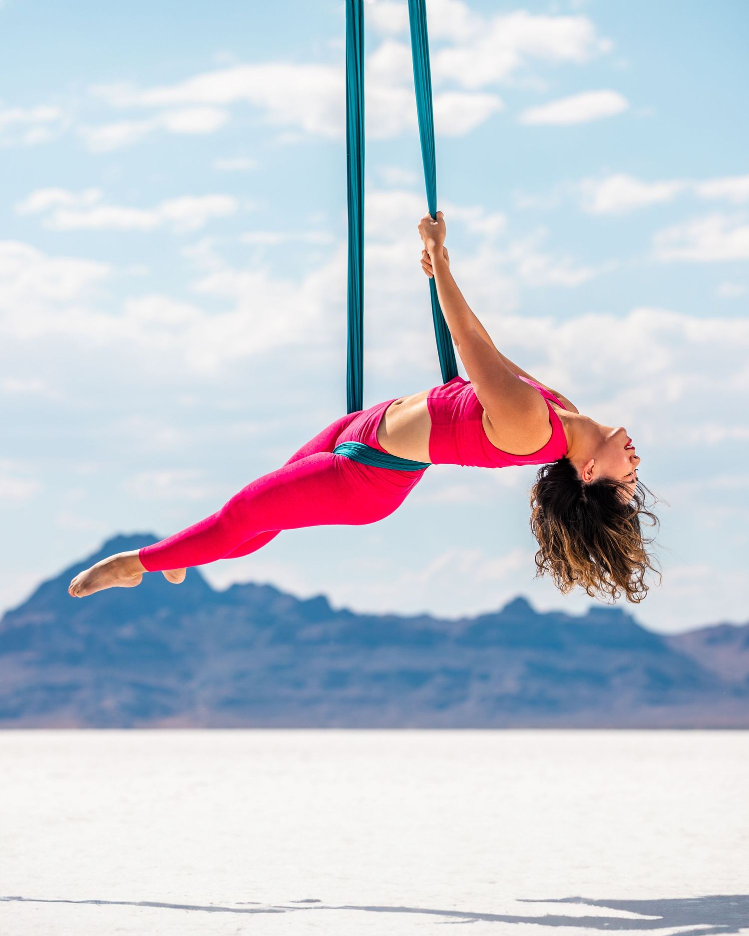 Aerialist in studio on white backdrop; professional aerial arts photography, aerial portraits, and aerialist photoshoot by expert photograph