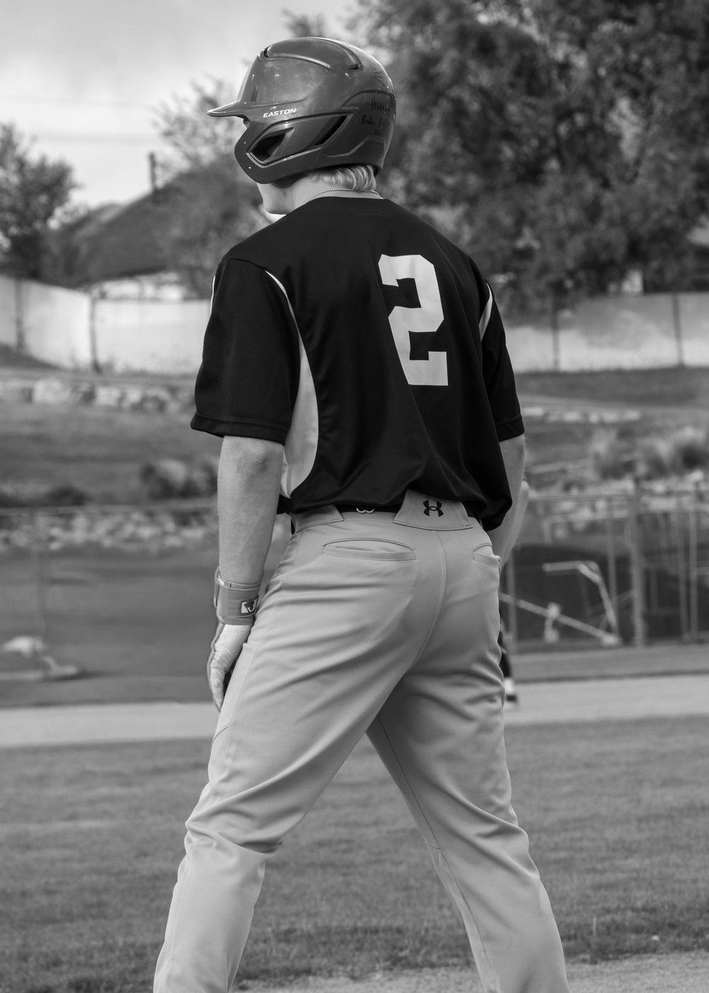 Black and white photo of youth baseball player in number 2 jersey standing on field.