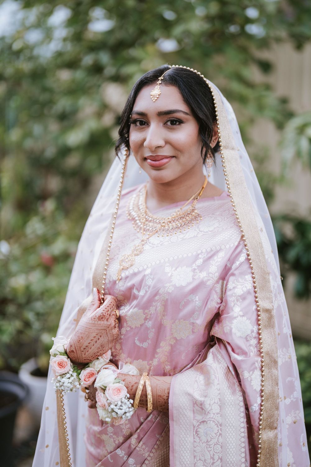 Bride portrait in blush pink saree and veil under trees in a Sydney park