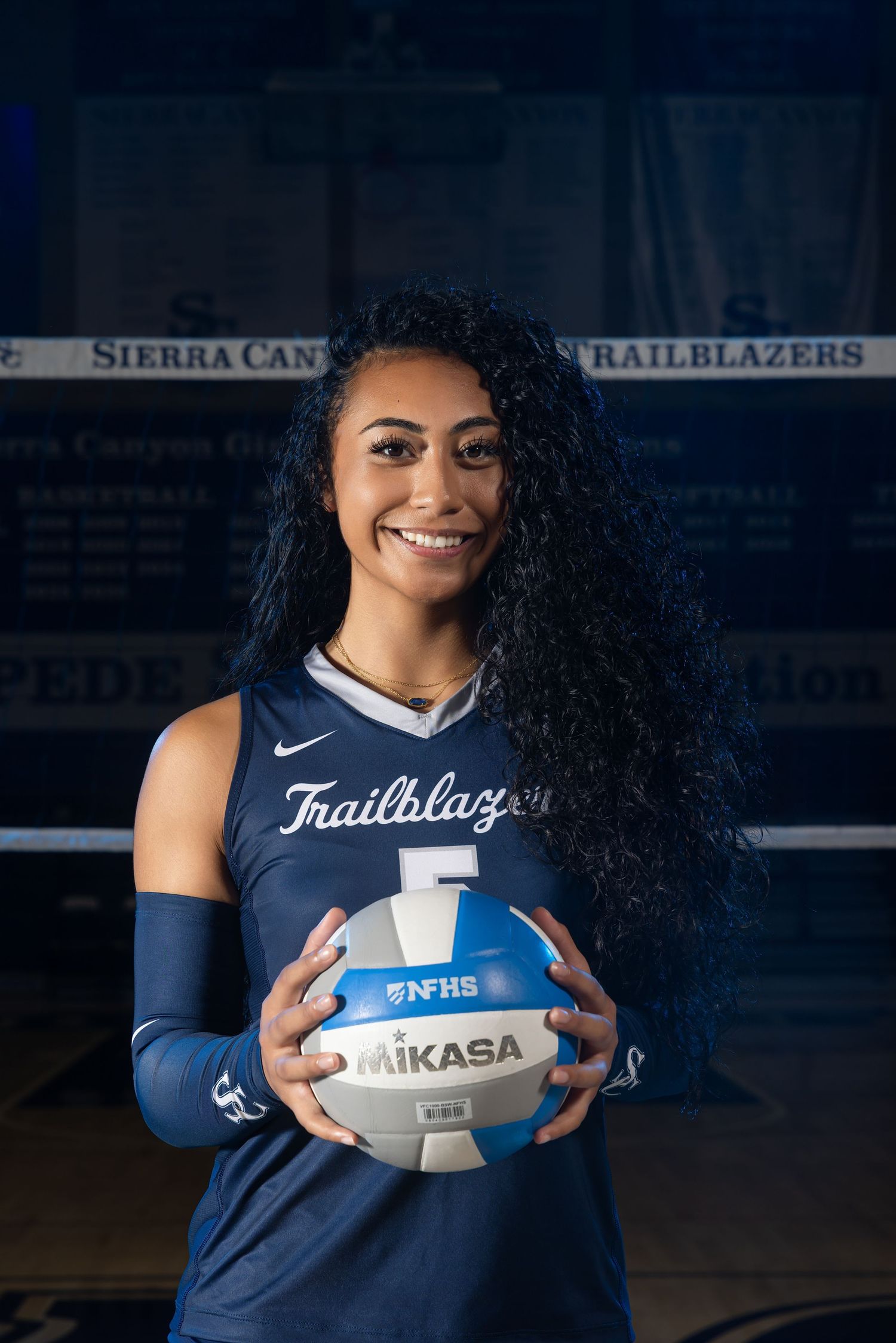 Sierra Canyon Trailblazers volleyball player #5 smiling and holding a Mikasa NFHS ball in team uniform.
