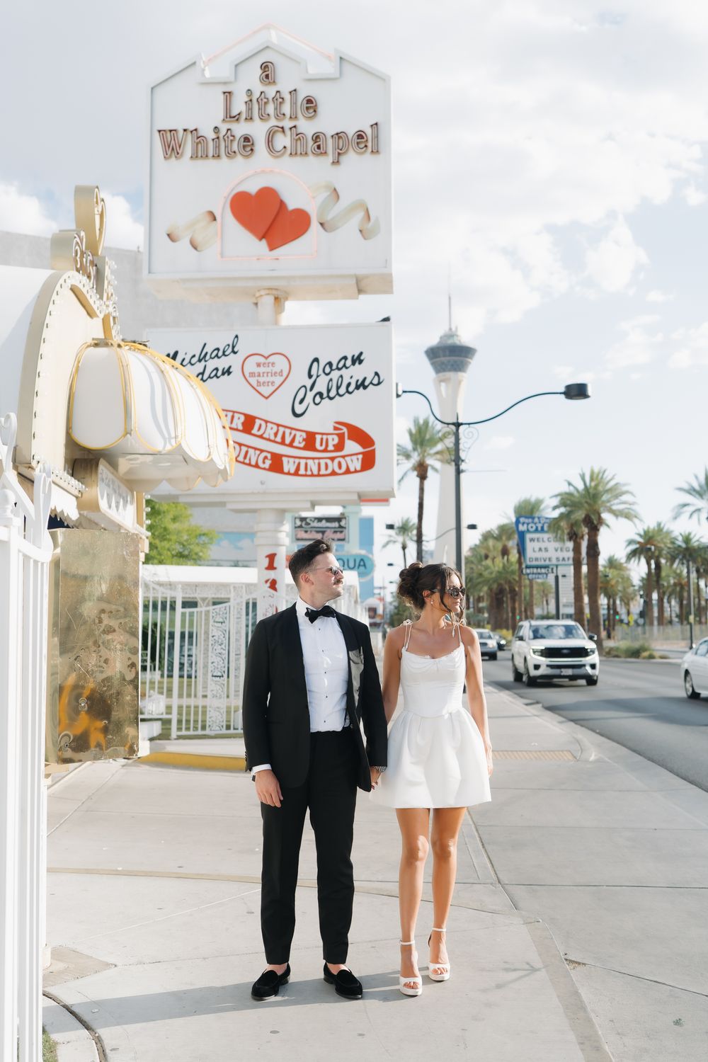 Couple poses outside the iconic Little White Chapel wedding venue on the Las Vegas Strip.