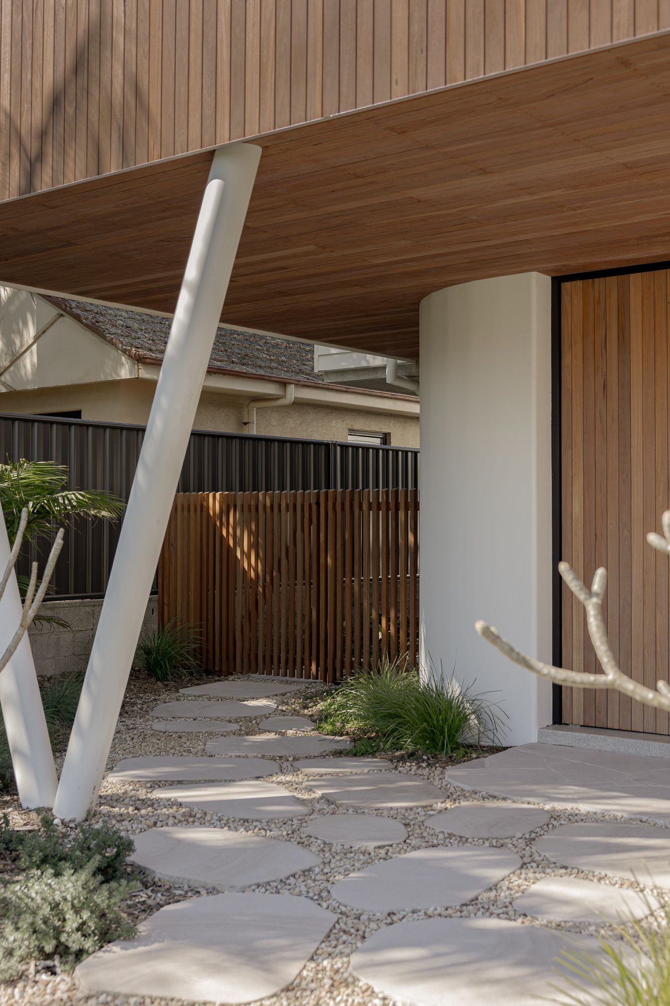 Entry with angled steel column, timber cladding and stone paving at a contemporary home in Shoalhaven NSW.