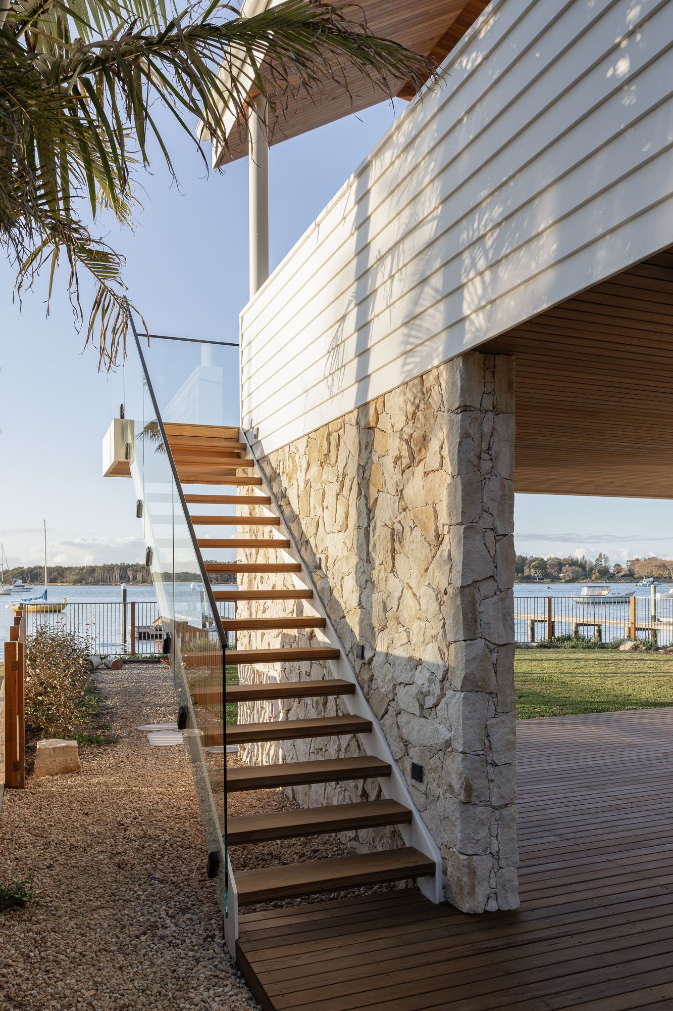 Exterior timber staircase beside white cladding with river views beyond, photographed at a new home in Shoalhaven NSW.