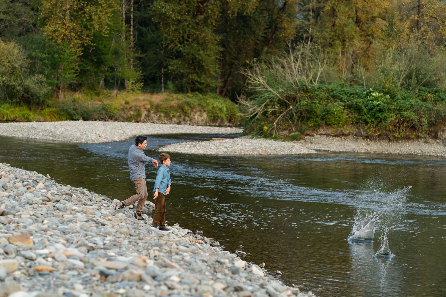 Dad and son throwing rocks into the Snoqualmie River.