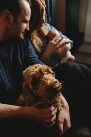 An intimate family moment with their Welsh Terrier dog in a cozy home setting.