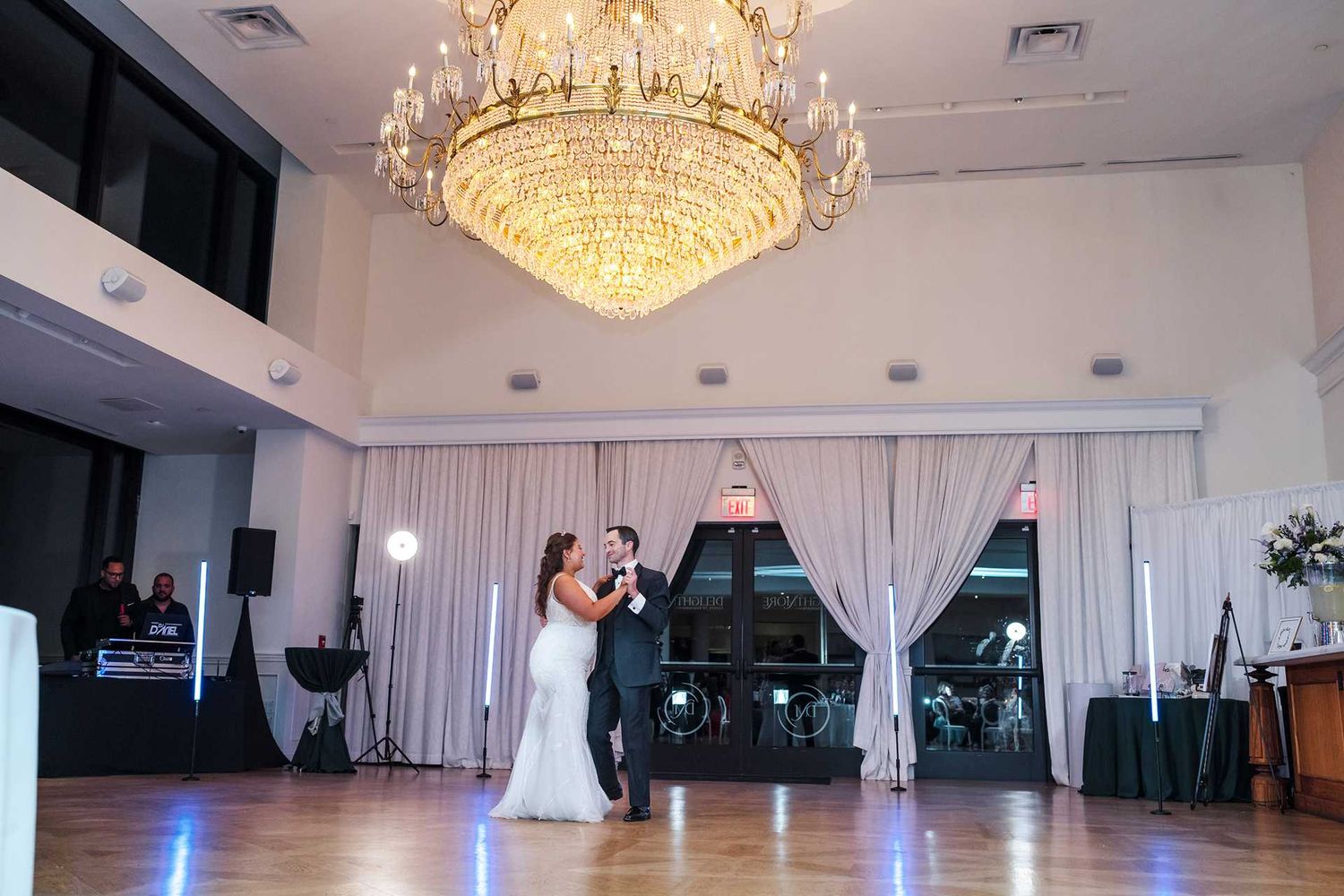 Bride and groom share first dance under elegant crystal chandelier at the view wedding venue