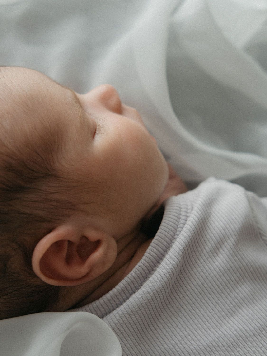 Primer plano de bebé recién nacido durmiendo sobre telas gustosas.