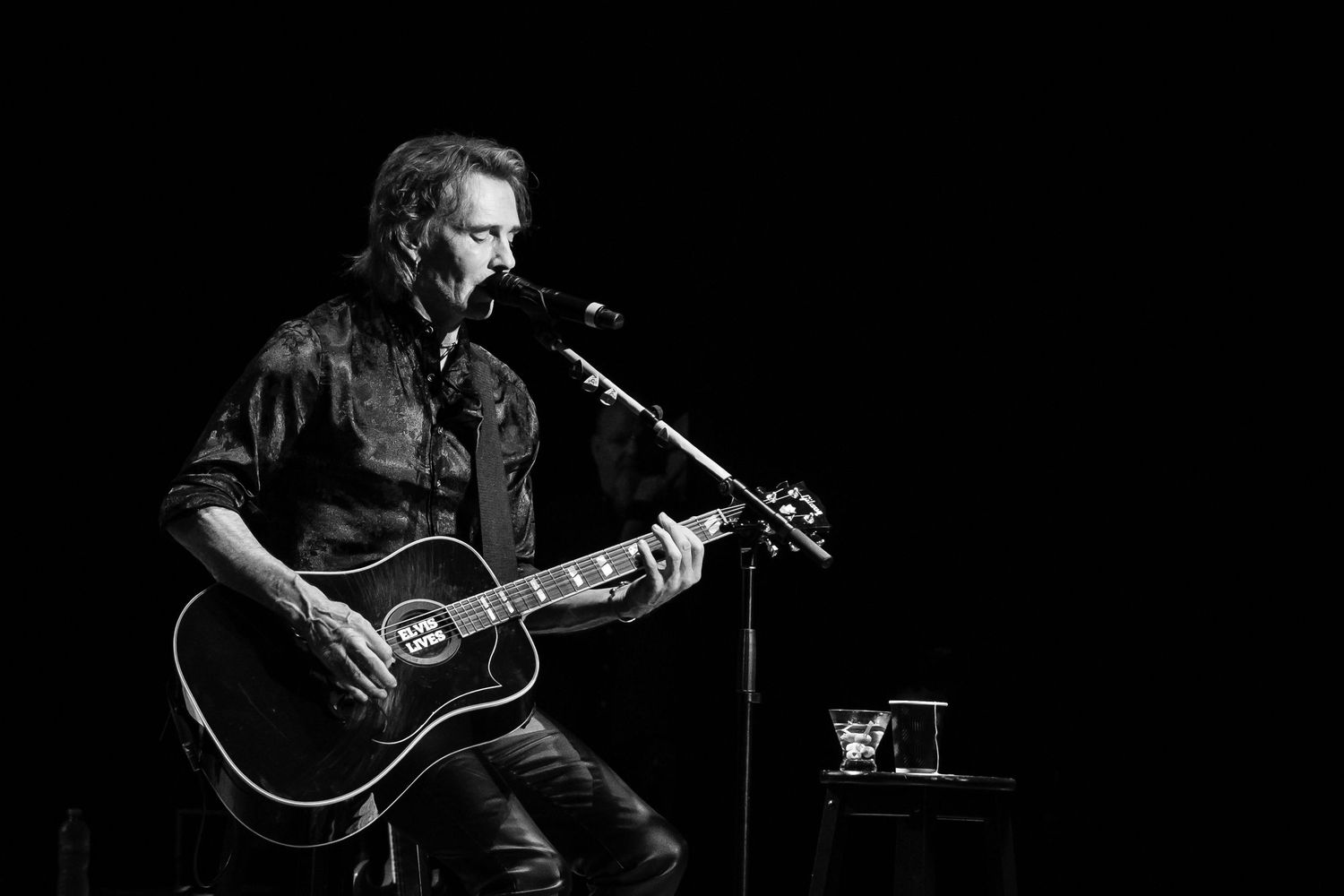 Rick Springfield plays an acoustic guitar during a concert in Gainesville, FL.