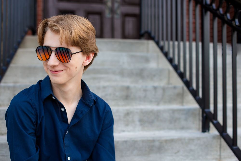 High school senior boy portrait in Howell, MI; headshot of boy sitting on steps with style, by South Lyon, Michigan photographer