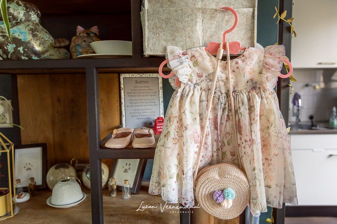 In de kast hangt de kleine trouwjurk voor de baby klaar, met roze schoentjes en een tasje waar de trouwringen in zitten