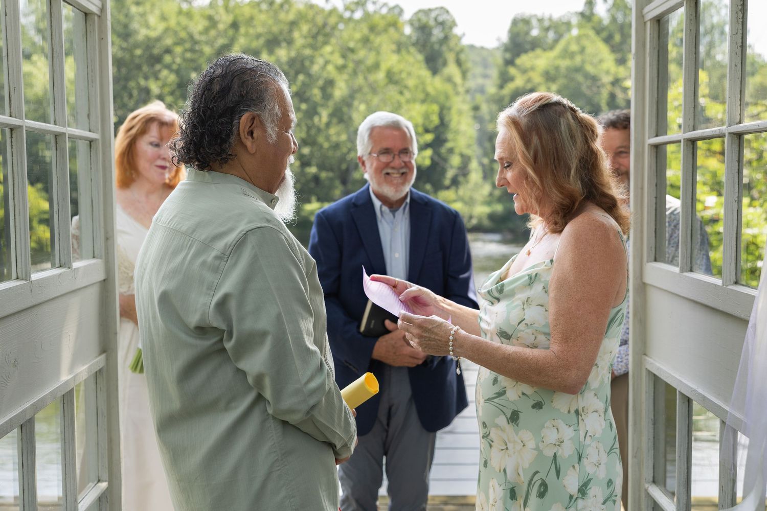 Small wedding gathering under a sunlit glass pergola by the Shenandoah River