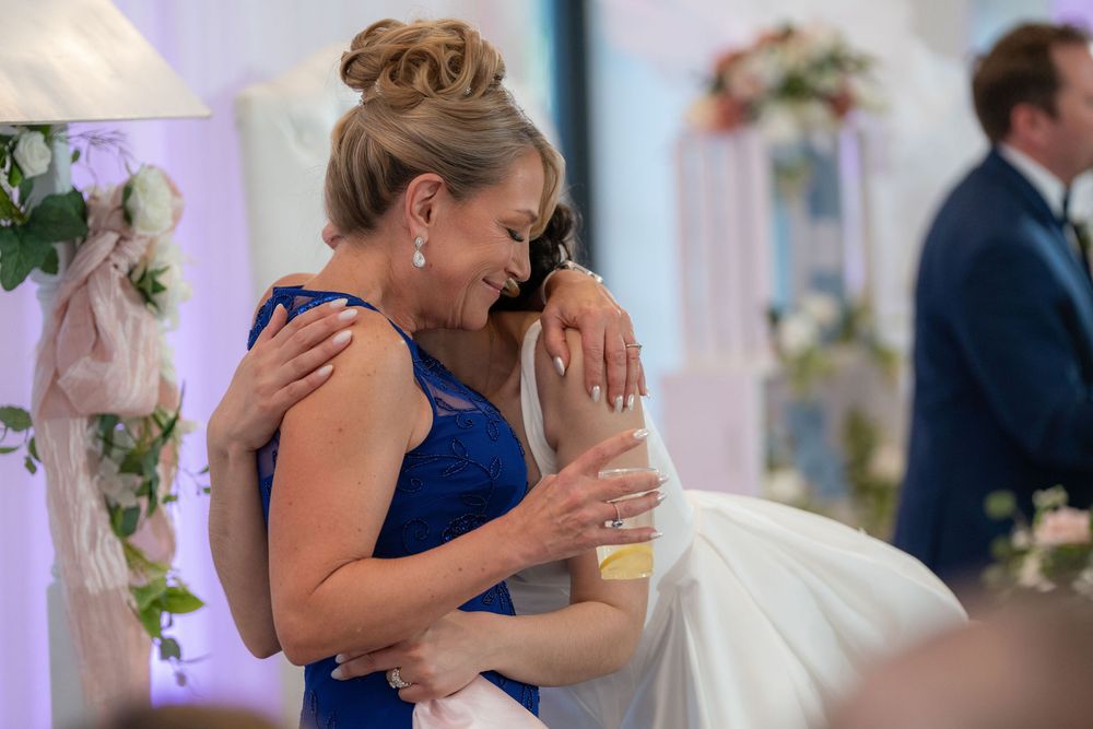 Bride embracing her mother during the reception at Tradition Town Hall in Tradition, FL