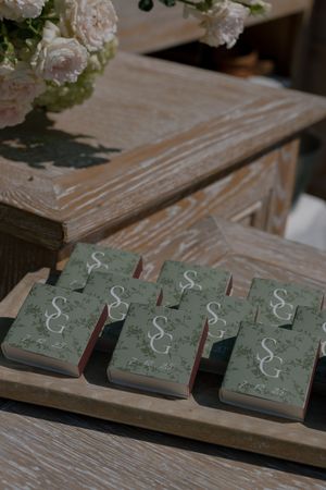 Decorative green and white floral coasters arranged in a row on a rustic wooden surface.
