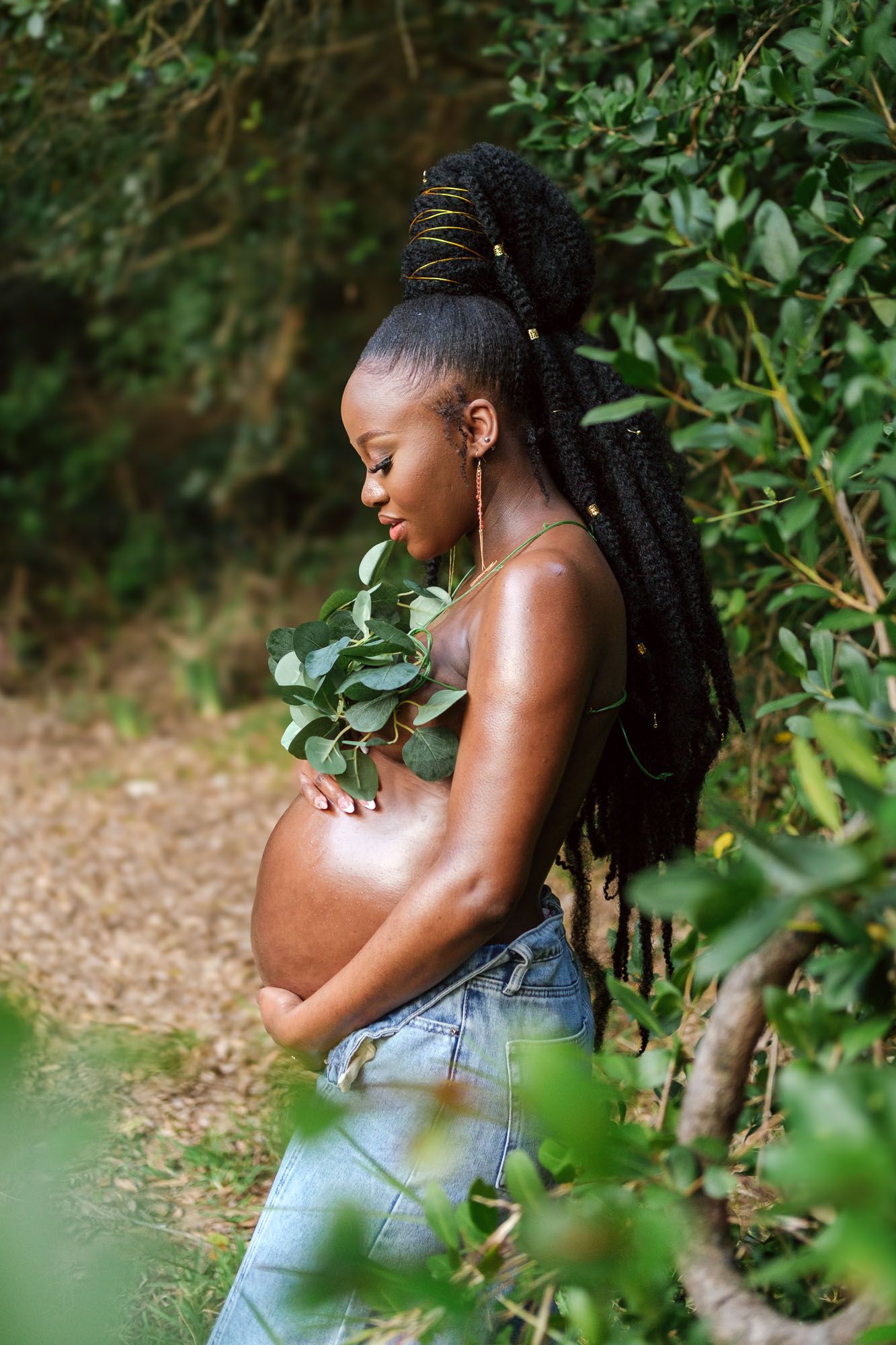 Pregnant mother gently holding her baby bump during an outdoor maternity photoshoot