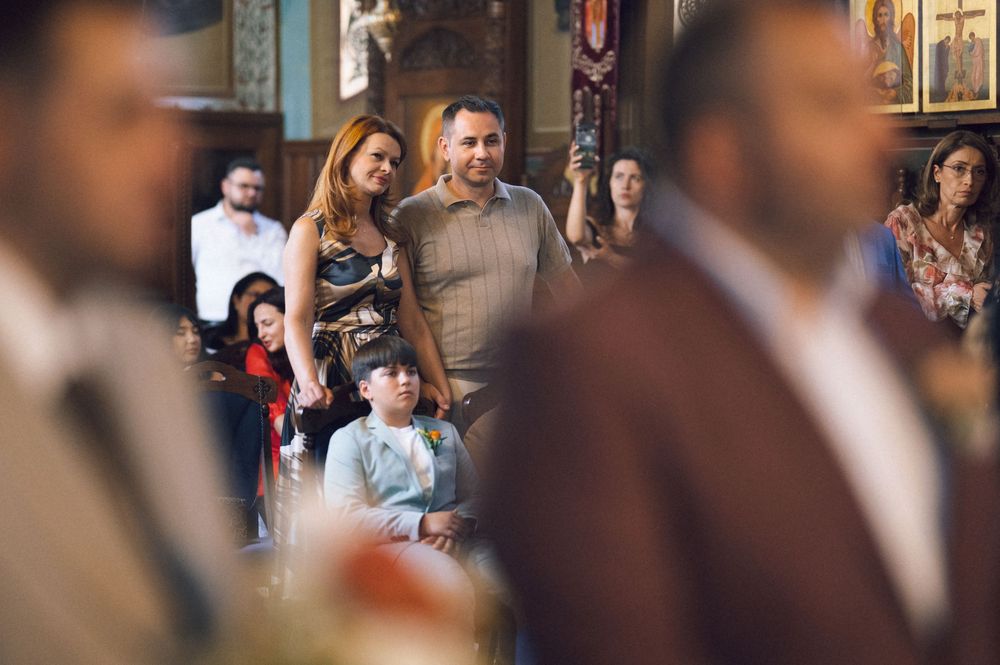 Family gathering in a church, with adults and children standing together during a religious ceremony.