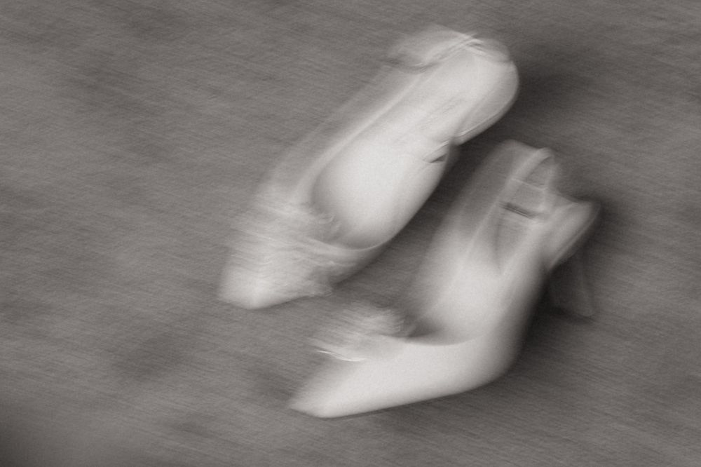 Blurred black and white photo of ballet pointe shoes in motion, creating an artistic abstract effect.