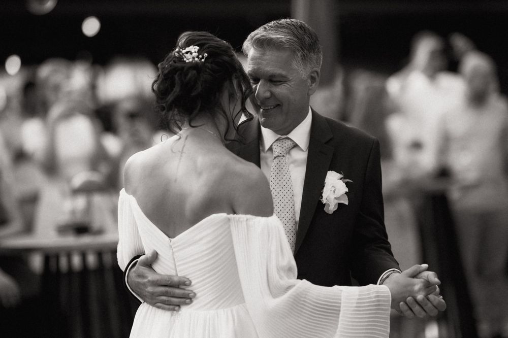 Black and white photo of a bride and groom sharing their first dance at an elegant wedding reception.