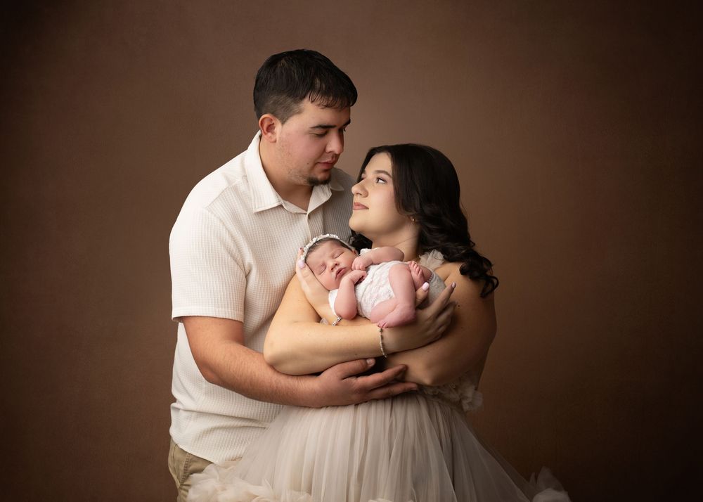 Parents holding their newborn baby during a studio newborn photography session in Linden, New Jersey.