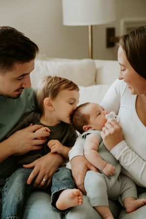 Parents cuddling their newborn baby during an intimate in-home lifestyle newborn photography session.