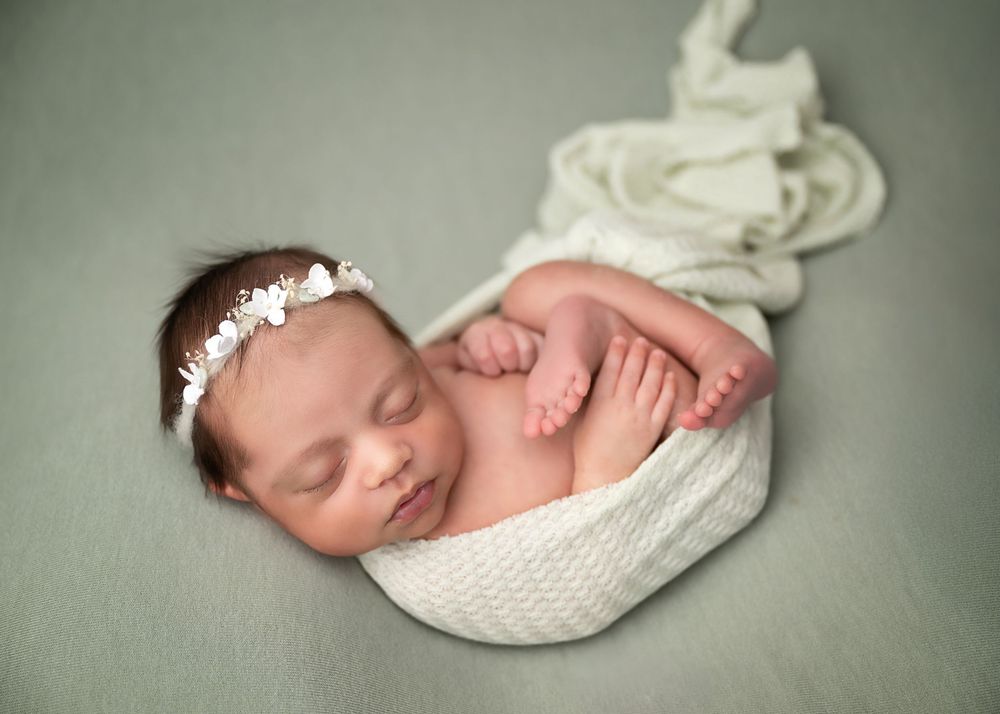 Newborn baby wrapped in soft teal during a posed studio newborn photography session in Linden, New Jersey.