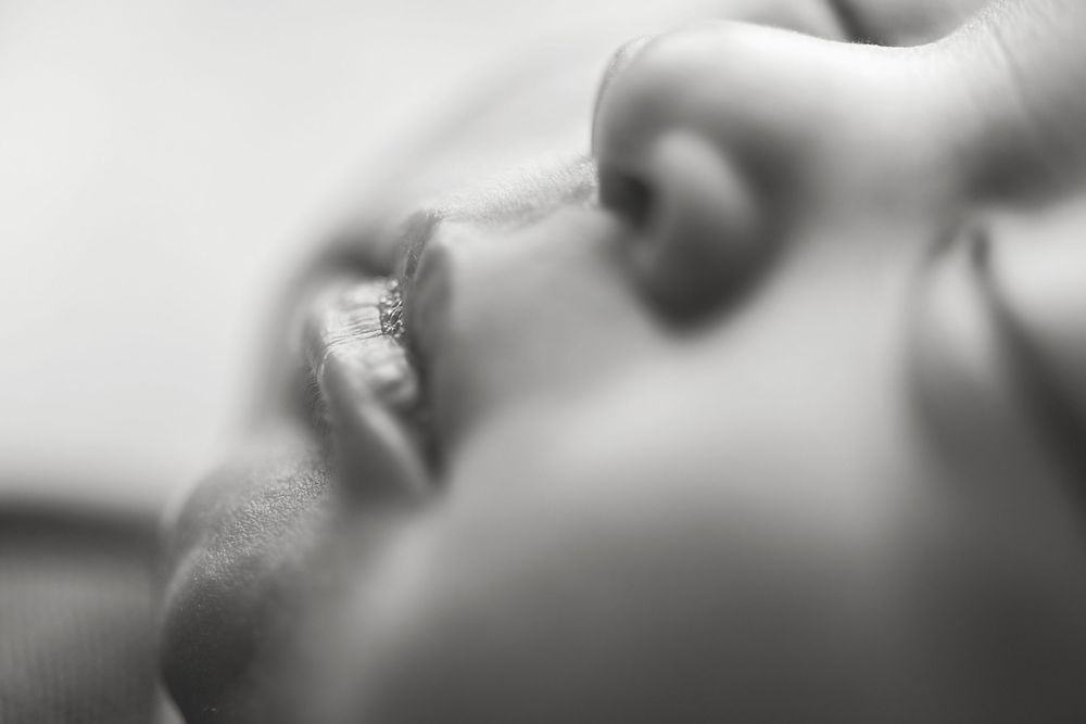 Soft black and white close-up of a newborn baby during a newborn photography session.