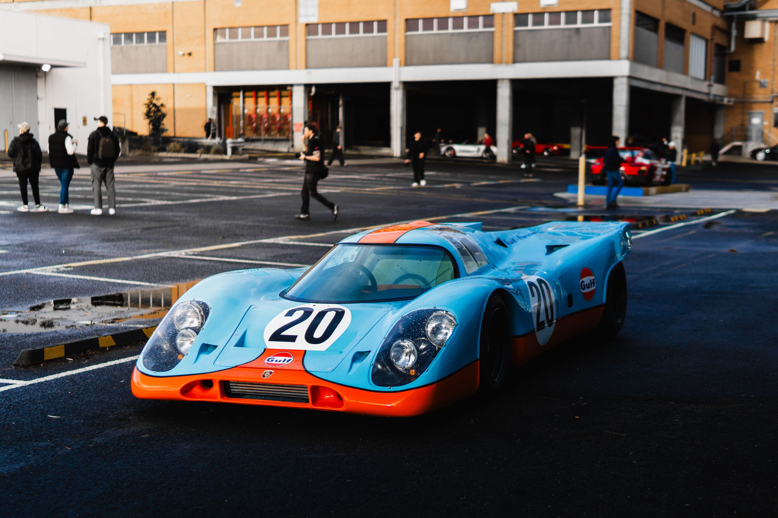 Gulf-liveried Porsche 917 race car number 20 in paddock area.