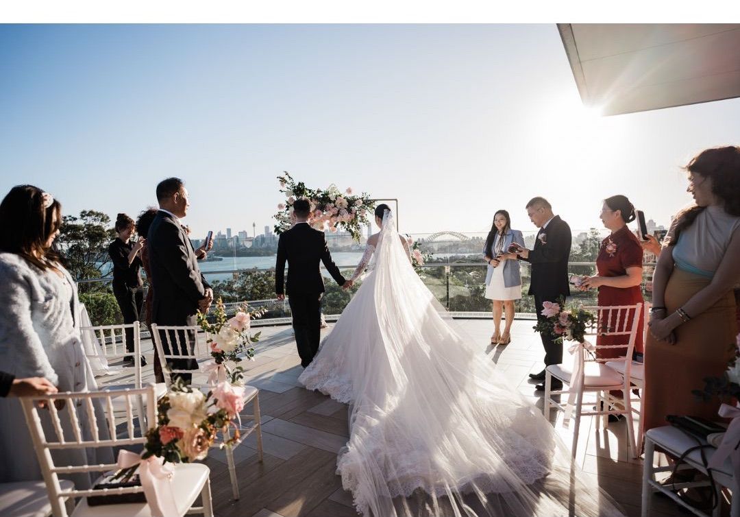 Bride and groom exchange vows at an outdoor rooftop wedding ceremony with Sydney Harbour Bridge views.