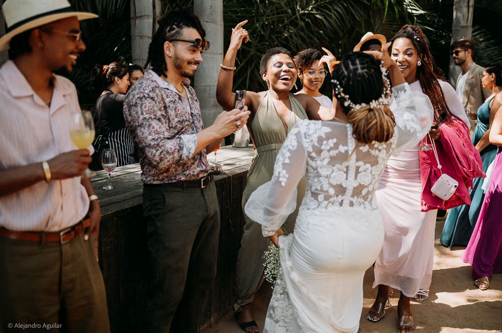Joyful wedding reception dance floor with bride in lace gown celebrating with guests outdoors.