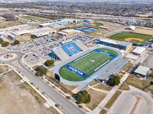 Wide aerial view of Temple ISD Wildcat Stadium complex with blue turf football field and surrounding facilities.
