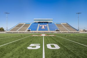 Ground level view of Temple Wildcats football field from the 50-yard line facing the main grandstand.