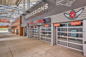 Stadium concourse featuring concession stands and Fire Barn restaurant with glass garage doors.