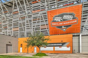 Exterior view of Robert & Janet Vackar Stadium entrance with orange concessions building.