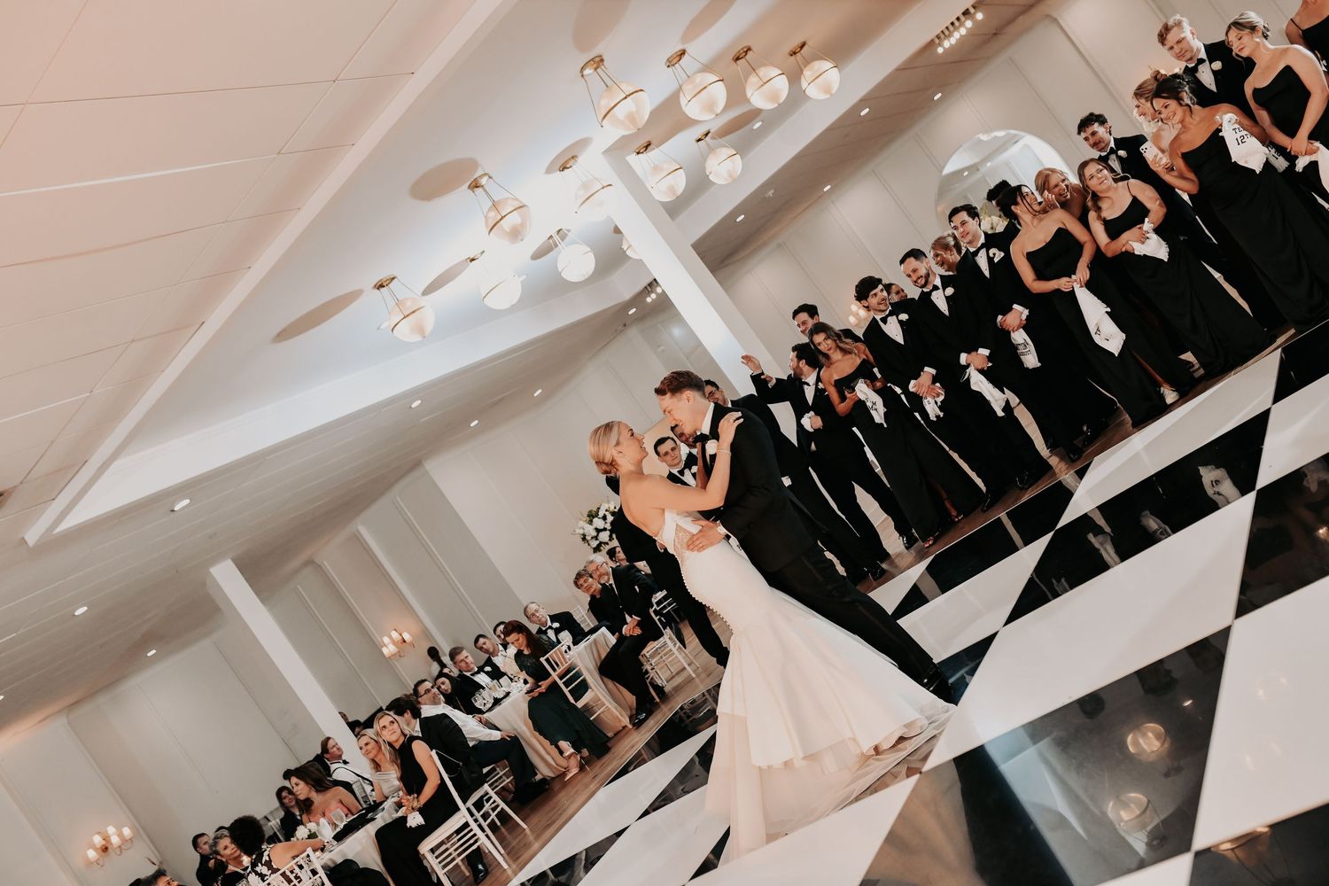 Newlyweds dancing together during their black-tie wedding reception