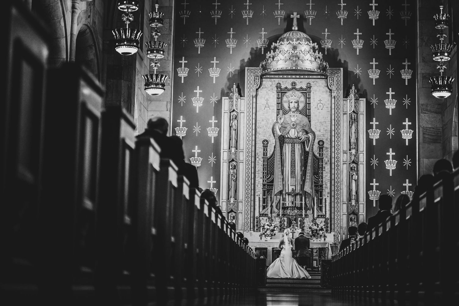 Bride and groom kneeling together during their Catholic wedding Mass