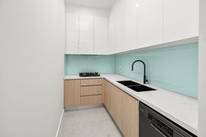 Modern kitchen with white upper cabinets, timber lower cabinets, mint green splashback, and black tapware.