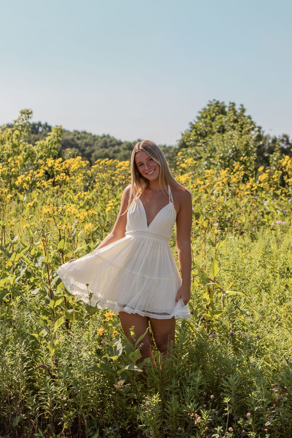 A blonde senior girl frolicking in a meadow in Strongsville.