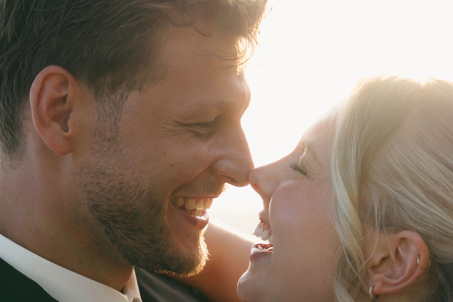 Bride and groom greeting guests outdoors at a rustic Spanish wedding venue with a guitarist performing in the background.