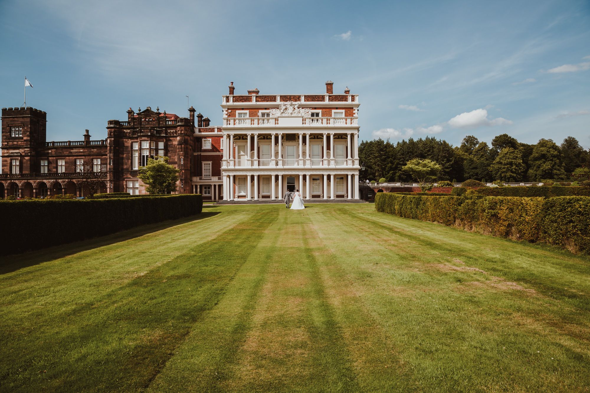 Bride and groom walking through the grounds of Knowsley Hall